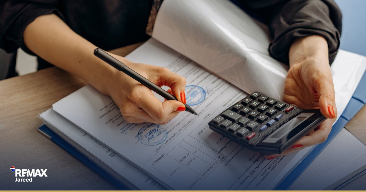 آلة حاسبة ومستندات تمويل عقاري على مكتب لحساب الأقساط الشهرية للشقة