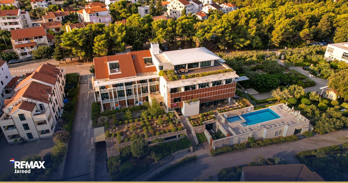 Aerial view of residential compound showing mix of villas townhouses and apartment buildings with landscaped gardens in Sheikh Zayed West Cairo